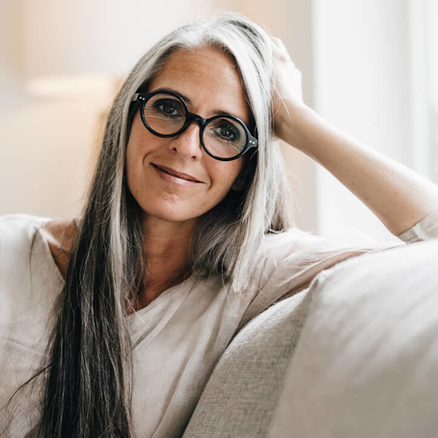 Frau mit langen grauen Haaren lächelt
